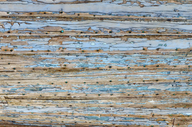 一个旧的木制渔船，特写，纹理为设计，浅景深，清晰度在顶部的框架，因为船的圆形形状。用钉子在木头上涂剥落漆，使表面风化图片下载
