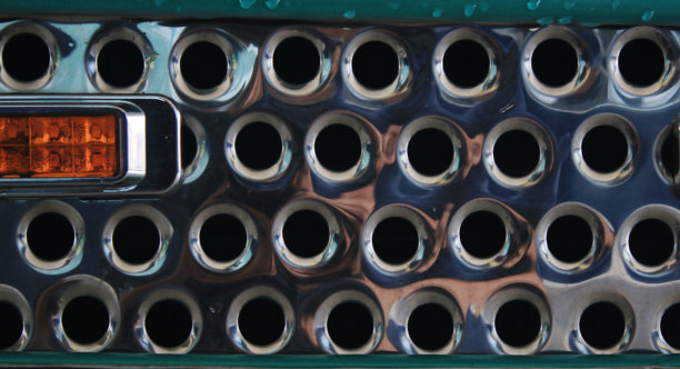 一个闪亮的金属栅格和一个橙色的光的特写图片下载