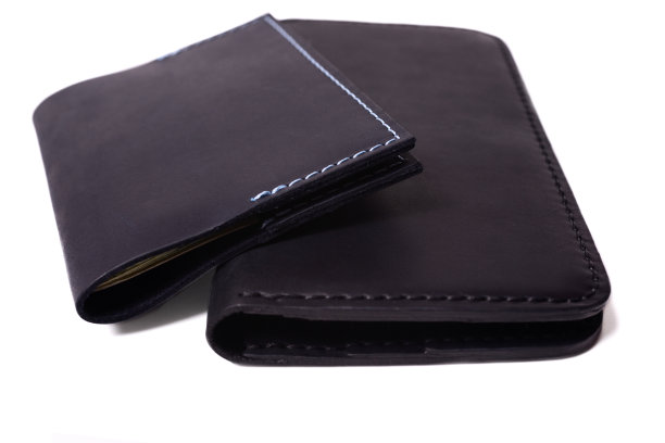 手工制作的蓝色护照封面和黑色钱包孤立在白色背景特写。孤立的手工奢侈品配件库存照片。图片下载