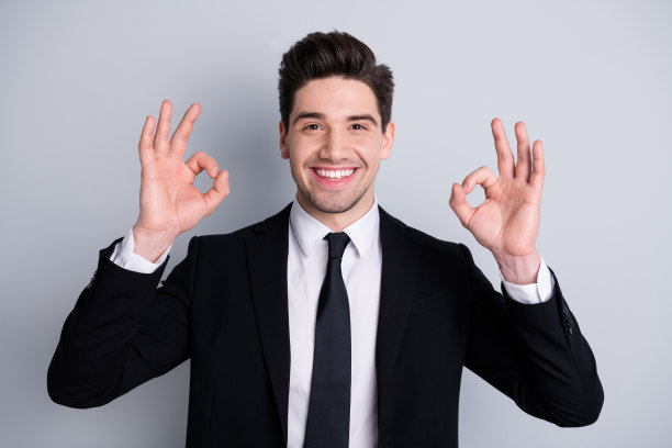 特写照片惊人，他，他，他的男子气概英俊的手，手臂，手指，好的象征，建议新测试产品质量穿白色衬衫，黑色西装，夹克，领带，正式的穿孤立的亮灰色背景图片下载