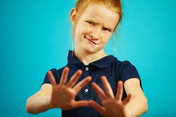 肖像的小女孩与不满的表情否认拉她的手到相机，显示排斥或拒绝。图片下载