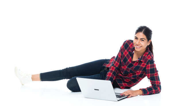 美丽年轻的拉丁美洲女性躺在地板上，用手提电脑图片下载