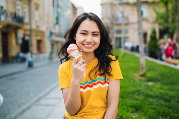 年轻的亚洲女人在吃冰淇淋图片下载