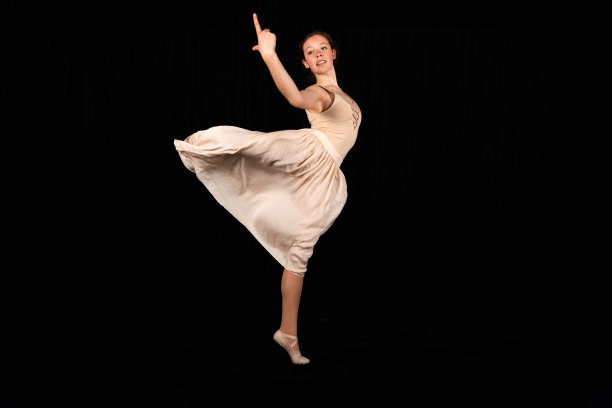 年轻的芭蕾舞演员在黑色背景上跳舞图片下载