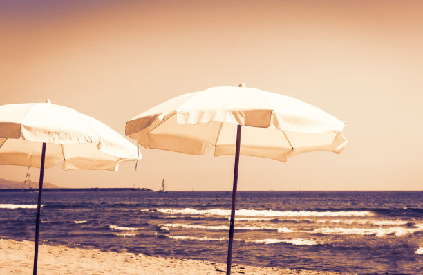 西西里岛日落，卡塔尼亚附近的爱奥尼亚海海滩，利多与白色伞。图片下载