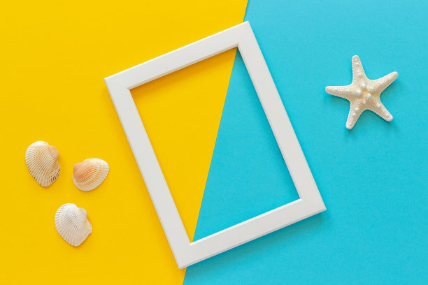 白色框架与海星在蓝色，黄色的背景和贝壳。创意平铺顶视图模板明信片，设计复制空间的文本图片下载