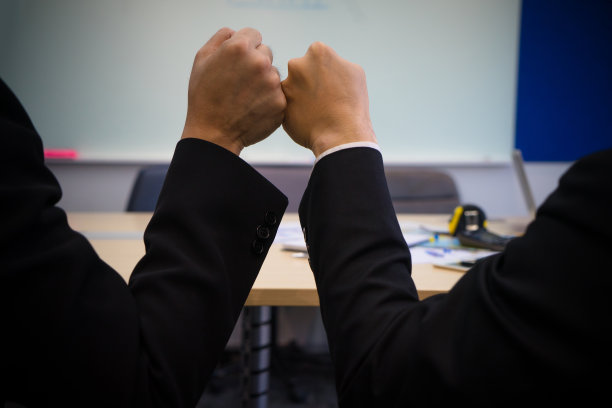 同事们紧握拳头结束办公室会议。使命完备，团队力量强大，伙伴支持信任图片下载