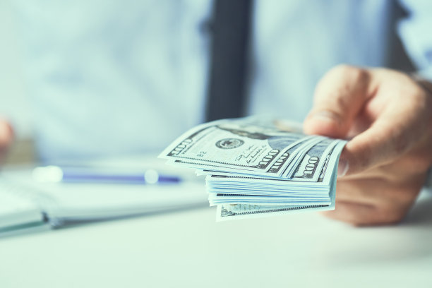 一个人给钱的时候手里拿着现金。货币信贷的概念。健美的图片。图片下载