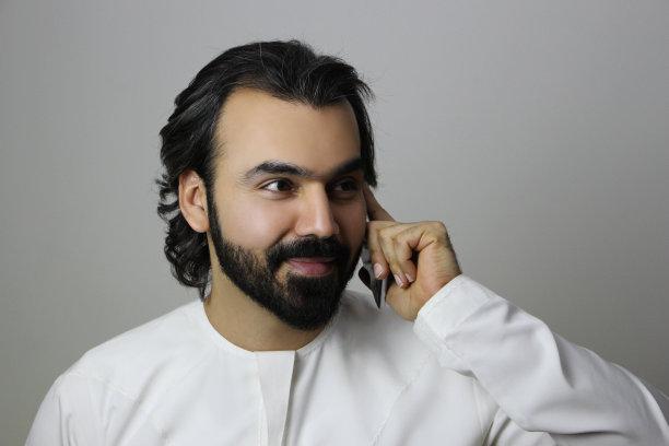 阿拉伯男子使用手机微笑图片下载