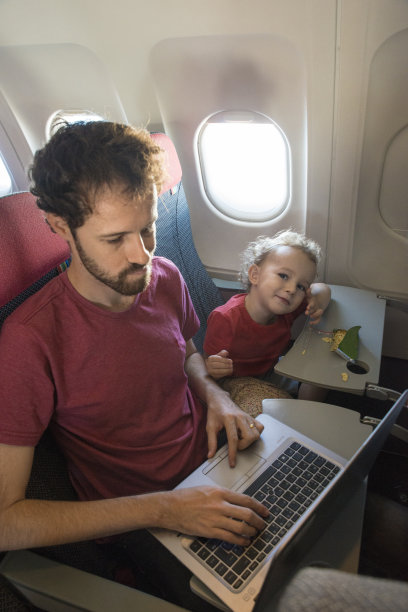 乘客工作的父亲和好玩的儿子在飞机上图片下载