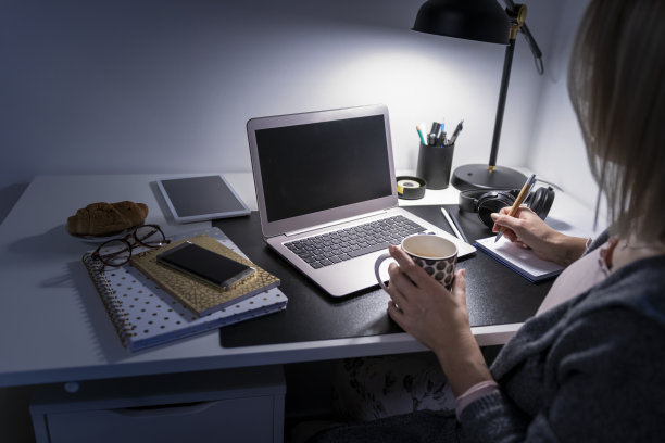 一个年轻女人在她的家庭办公室工作到很晚图片下载