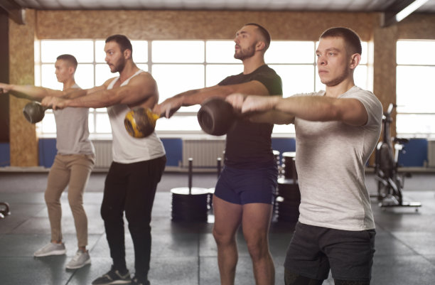 在健身房用壶铃训练年轻男子。图片下载