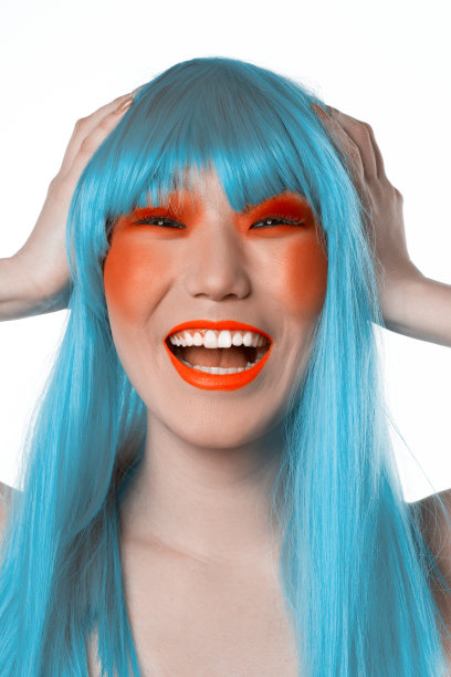 年轻的笑亚洲女人在蓝色假发图片下载
