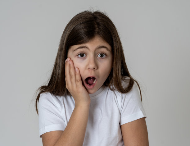 可爱的肖像快乐，兴奋，有趣，开朗的年轻女孩震惊惊讶的脸手指指向一些好的和意想不到的。儿童和积极的人类情感和表达。图片下载