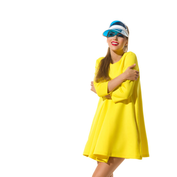 穿着黄色迷你裙和遮阳板的微笑女人正在看别处图片下载