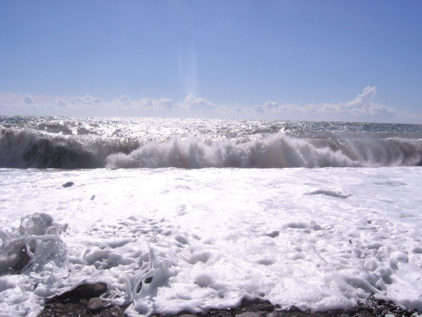 壮阔的海浪带着白色的泡沫在海边拍打着海岸图片下载