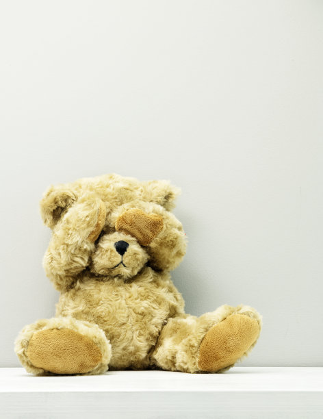 害羞的小泰迪熊玩具盖着她的脸图片下载