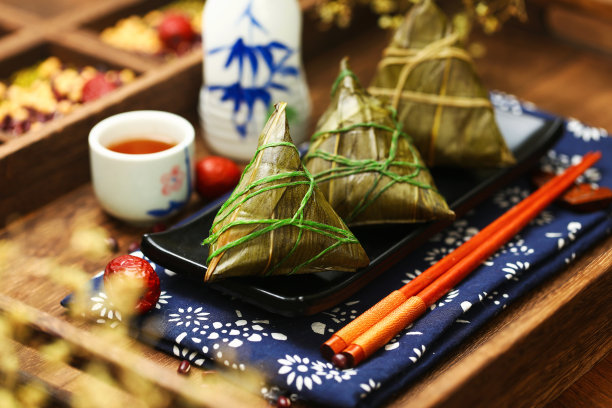 黑色餐盘上的中国端午节粽子和酒素材图片
