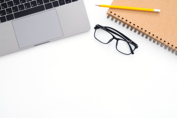 创意平面办公桌照片。顶视图办公桌，笔记本电脑，眼镜，铅笔，笔记本和植物在白色的背景。顶视图与复制空间，平铺摄影。图片下载