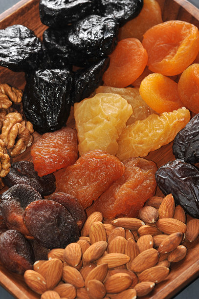 在图片中，一个盘子的一部分，其中放置的杏子，杏子，杏子，背景，棕色，特写，复制，蔓越莓，枣，美味，甜点，饮食，干，能量，无花果，食物，水果，水果，绿色，组，榛子，健康，健康梅子，干桃子和梨，杏仁。图片下载