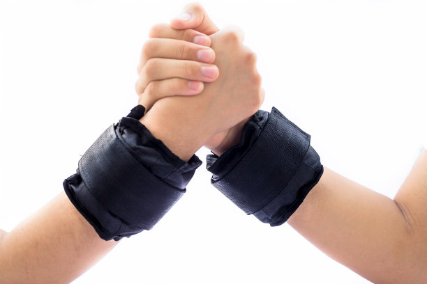 合上两只手，一只是雄性的，另一只是雌性的，互相扶持。他们都戴着黑色的护腕。图片下载