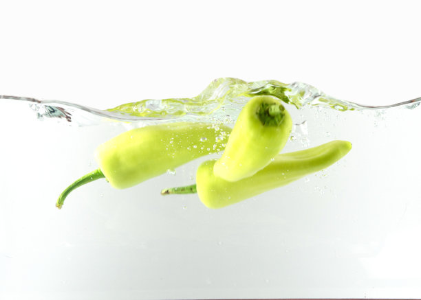 青椒在水中孤立在白色的背景。图片下载