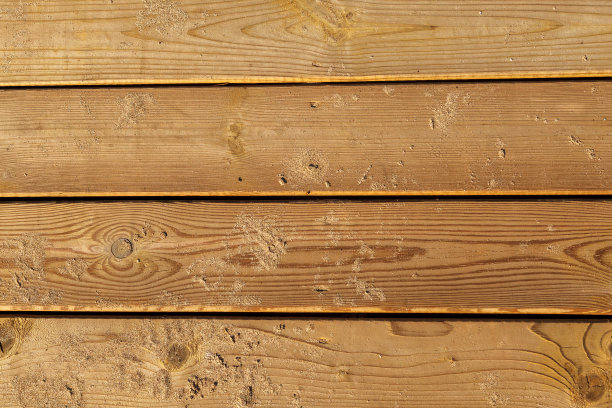 木制背景。董事会在沙子。沙滩上风化的木板路。天然材料。木材表面纹理图片下载