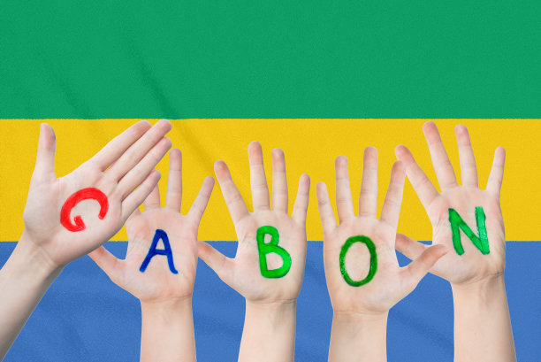 题词加蓬儿童的手，背景是飘扬的加蓬国旗图片下载