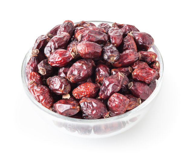 干燥的野玫瑰浆果在玻璃碗孤立在白色背景与修剪路径图片下载