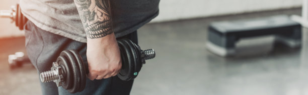 全景照片超重纹身男子训练与哑铃在健身房与复制空间图片下载