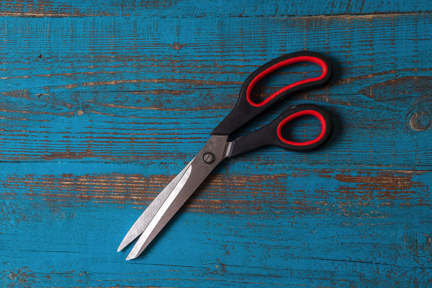 一双用过的厨房剪刀，背景是旧的蓝色木头。图片下载