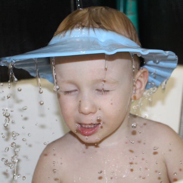 水倒在一个小男孩的头上。图片下载