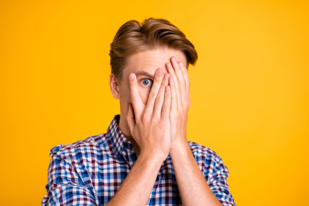 近距离的照片惊人的他他他的男人手臂手指隐藏眼睛充满恐惧哦没有面部表情史诗般的失败丢失了恐怖电影穿休闲格子衬衫装孤立的黄色明亮的背景图片下载