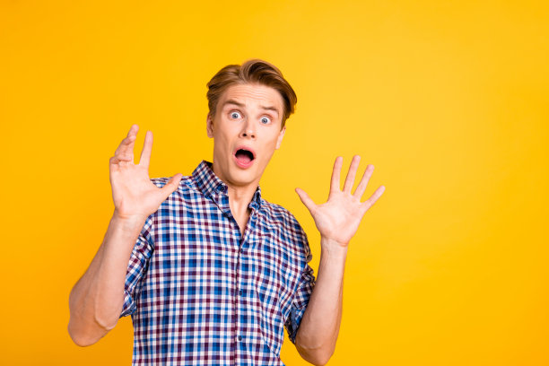 近距离的照片惊奇他他他的男人嘴巴张开眼睛充满恐惧哦没有面部表情双手举起空气问停止穿休闲格子格子衬衫外套孤立的黄色明亮的背景图片下载