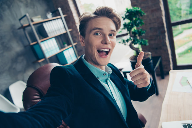 肖像积极开朗的年轻人放松休息休息暂停视频电话做照片坐桌子桌子广告选择决定推荐优秀的反馈夹克时尚时尚帅气的工业室内图片下载