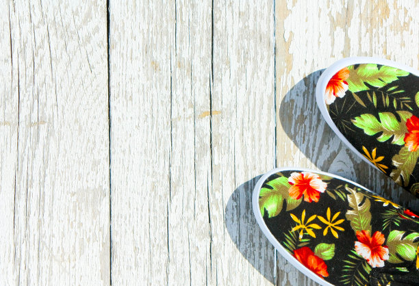 黑色带花运动鞋在白色木制背景。图片下载