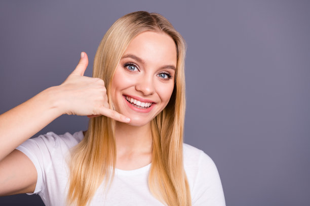 近距离的照片美丽的惊人的漂亮的她她夫人使手指电话符号靠近耳朵听顾客提供最好的在线免费服务穿休闲的白色t恤孤立的深灰色背景图片下载