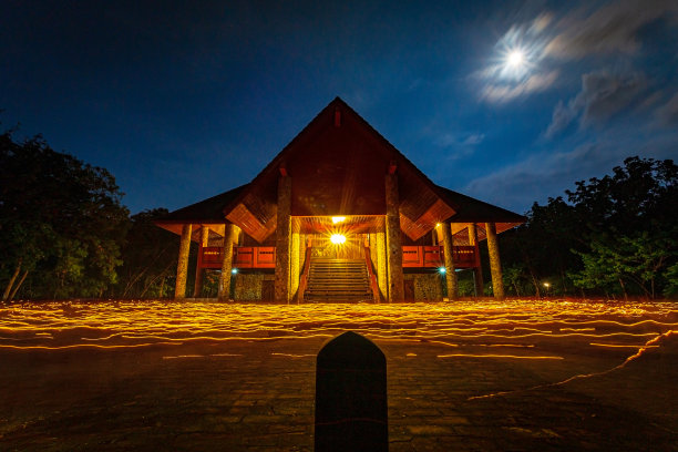 佛教徒手持点燃的蜡烛绕着一座寺庙走着，向三关致敬，长时间曝光图片下载