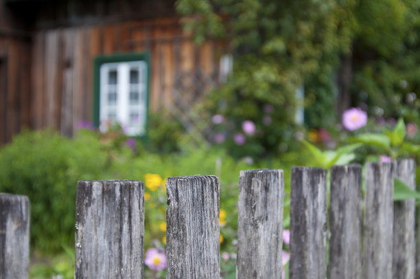 木栅栏前的老房子与美丽的花园在乡下-奥地利图片下载