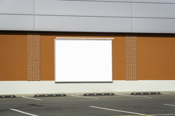 在一个空的停车场旁边的建筑墙上的水平空白广告牌图片下载