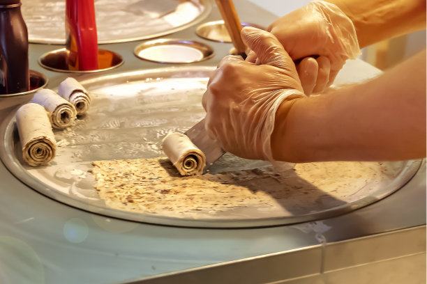 冷冻铁板上制作泰国街头甜点炒冰淇淋卷，手工冰淇淋甜点，选择性聚焦图片下载