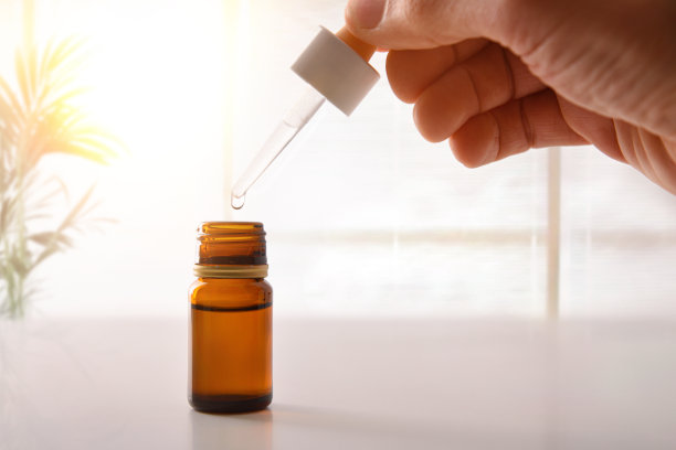 手拿移液管和带药室的棕色玻璃容器图片下载