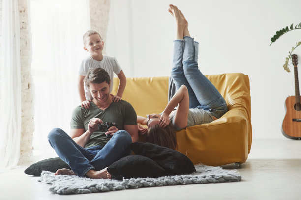 简单的对话。一对年轻夫妇和孩子一起看着相机拍的照片图片下载