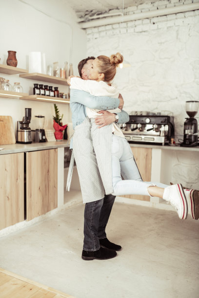 女人跳上她丈夫的怀抱。图片下载