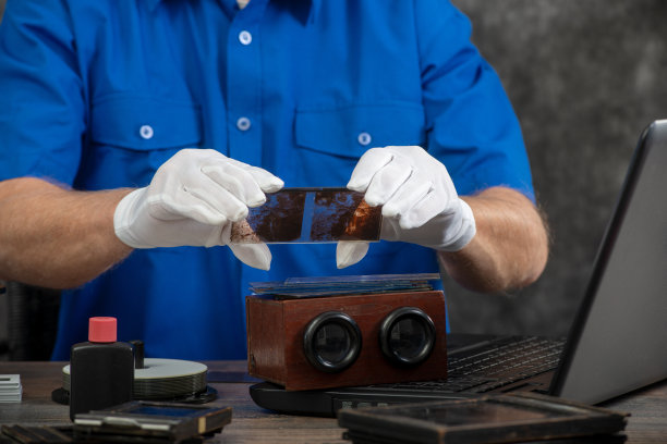戴着白手套的技术人员将旧照片在玻璃板上数字化图片下载