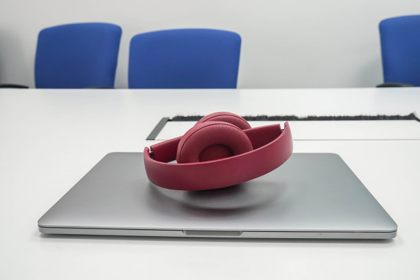 可爱的女性可折叠无线耳机和工作场所的笔记本电脑图片下载