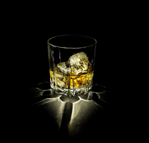 一杯威士忌和冰孤立在一个黑色的背景图片下载