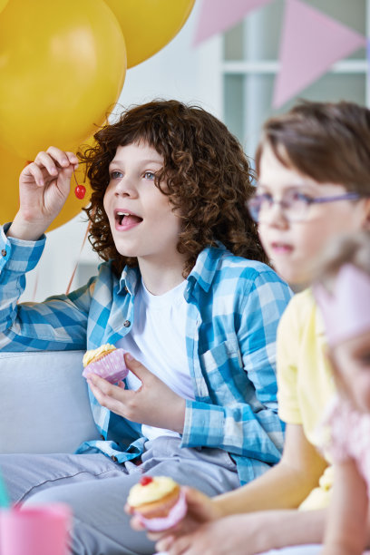 男孩们在生日派对上吃纸杯蛋糕图片下载