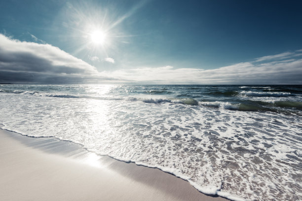 海滩上的波浪被太阳照得闪闪发光图片下载