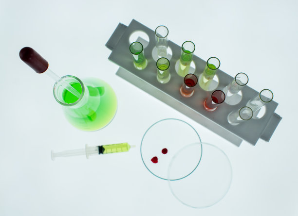 白色背景上放置锥形烧瓶、培养皿、试管和注射器，注射器内有血滴。图片下载